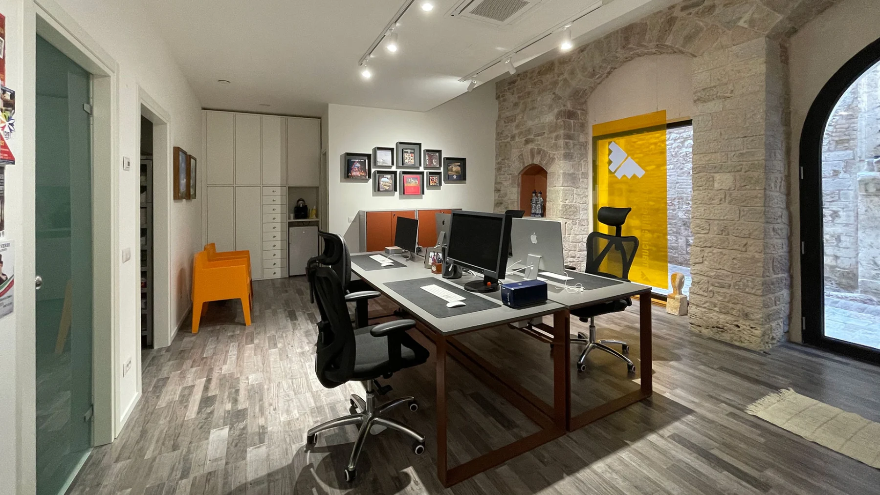 Interno dello studio con le scrivanie e la porta a vetri