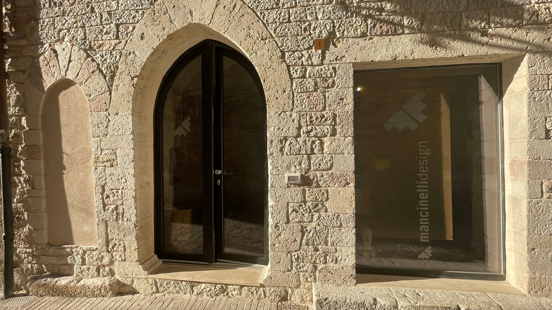 L'ingresso dello studio Mancinelli Design ad Assisi, con il logo sulla porta a vetri